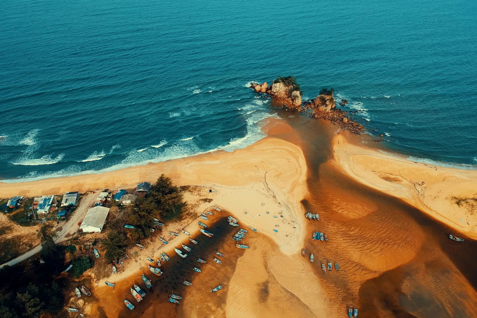 Dramatic aerial shot showcasing a pristine beach merging with blue ocean waters.
