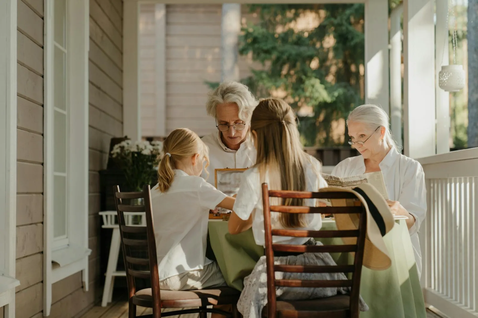 Multi-generational family sharing a moment on a sunlit veranda, capturing togetherness.