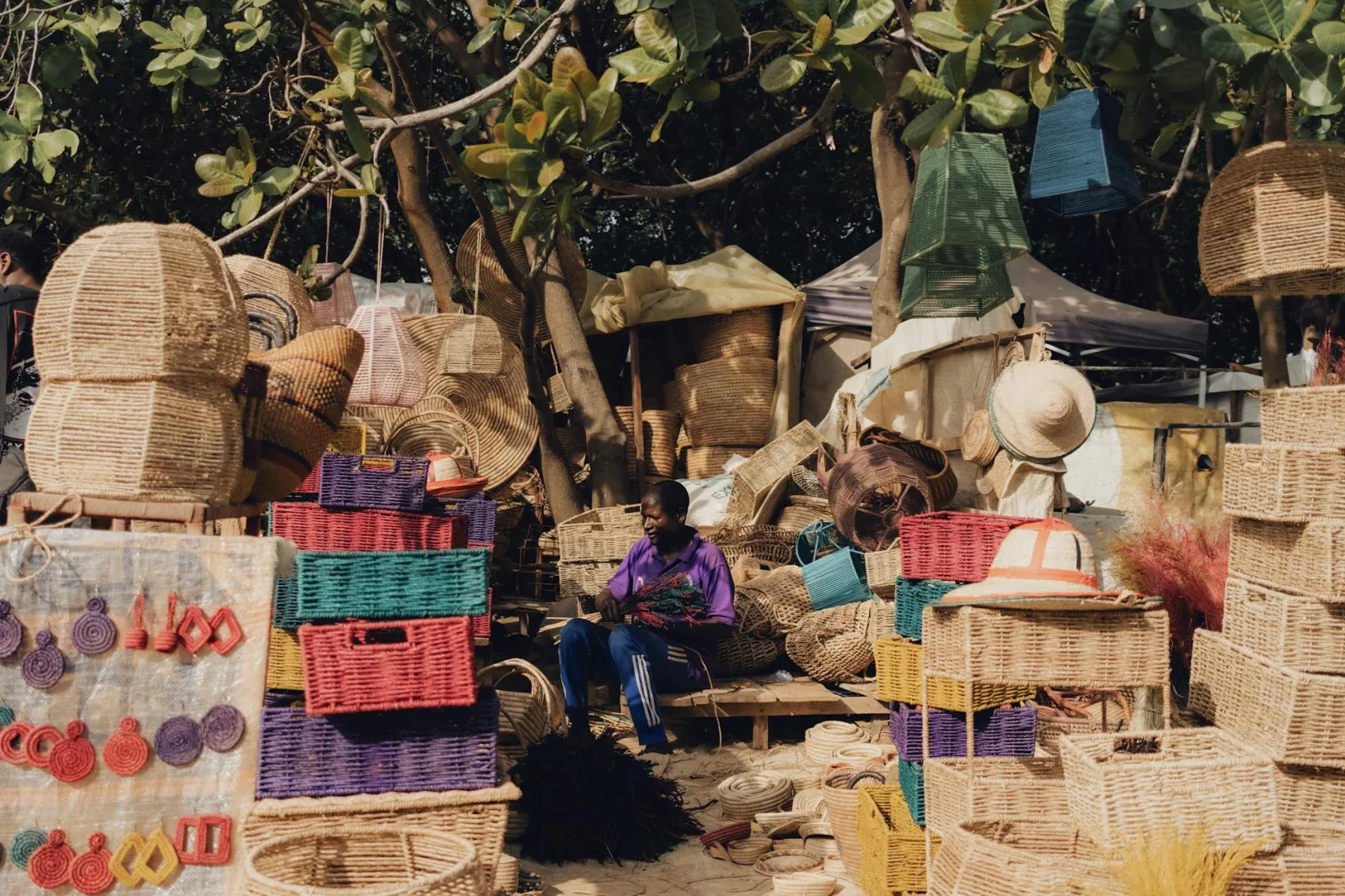 Colorful handmade baskets and crafts displayed at an outdoor Nigerian market.
