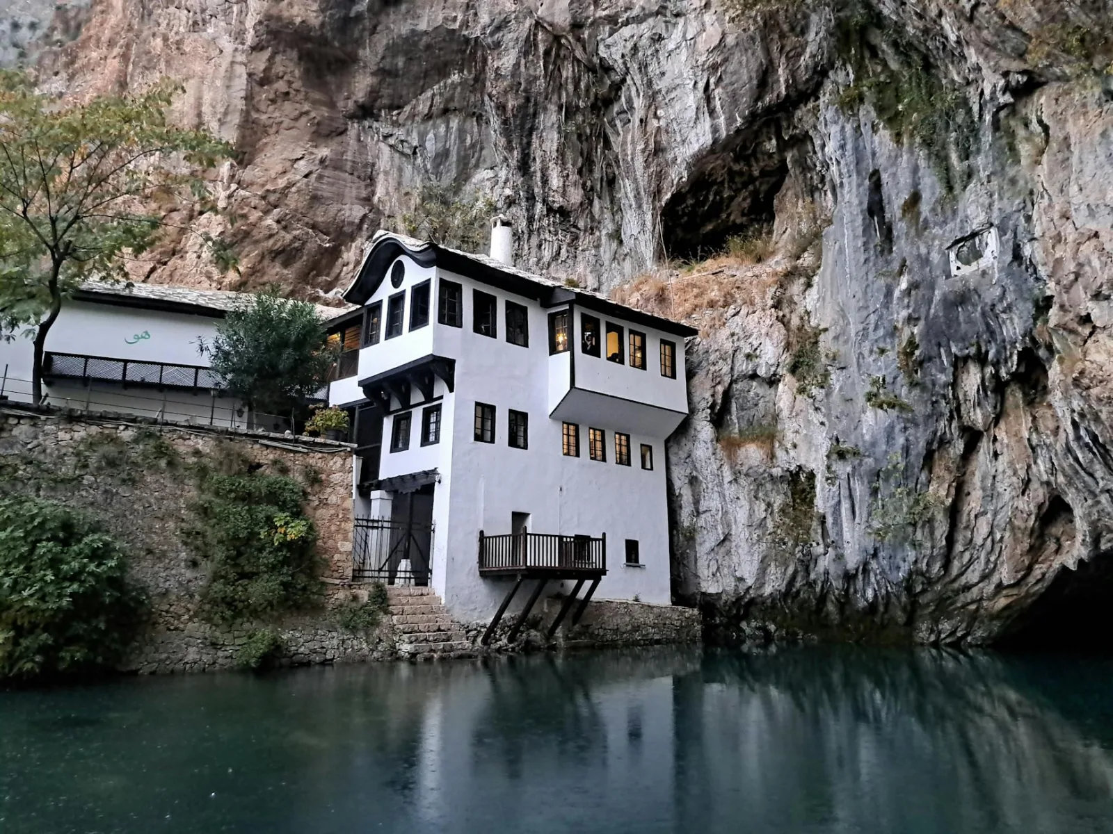 Historic Blagaj Tekija positioned by a serene river and cliff.