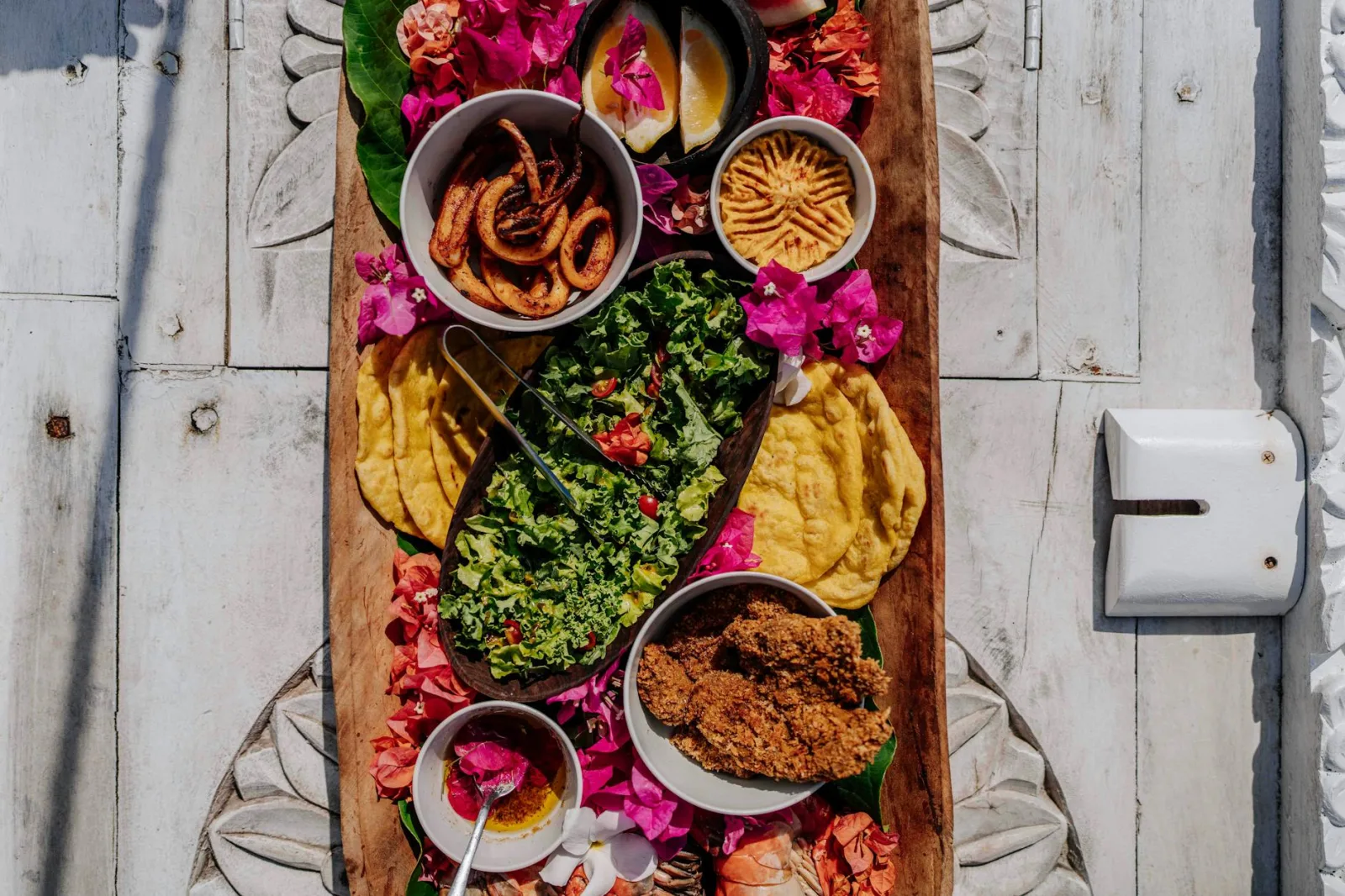 A colorful platter featuring diverse local Zanzibar dishes and flowers.