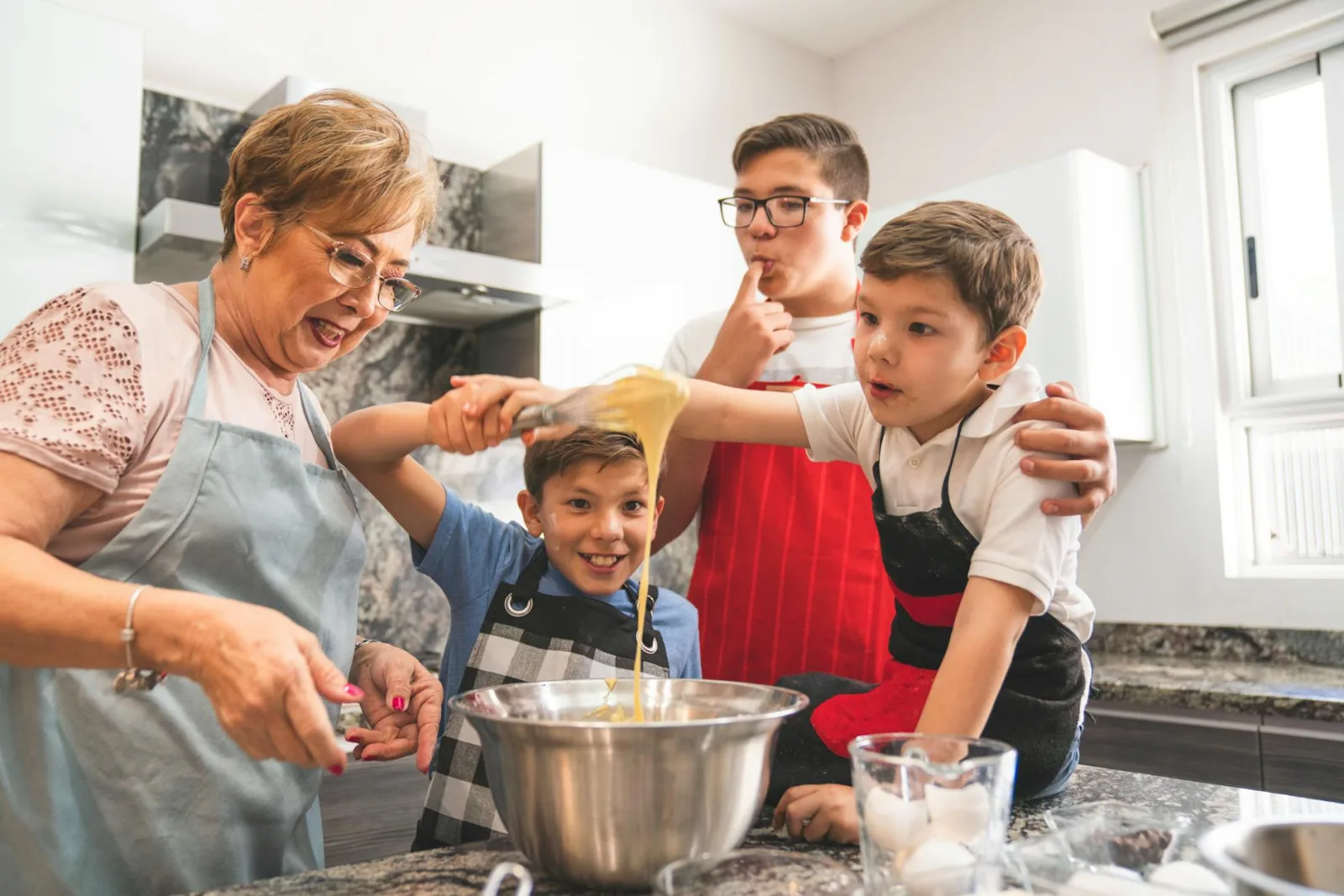 Grandmother and grandsons enjoy baking together, creating special memories in the kitchen.