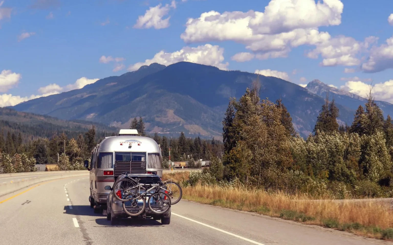 RV traveling on a scenic mountain highway with bikes. Perfect summer adventure.