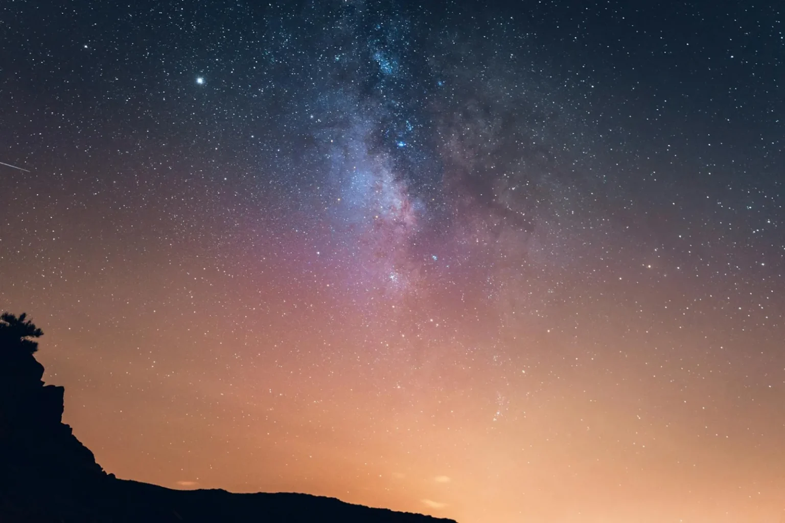 Breathtaking view of the Milky Way over a silhouetted mountain at night in Spain.