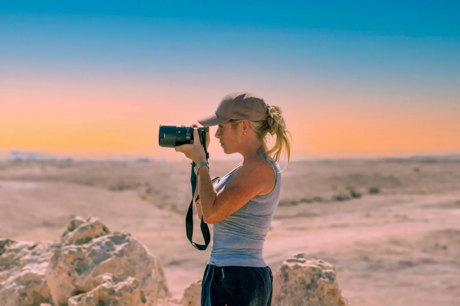 A serene moment of a female photographer capturing the desert's beauty.