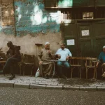 Local men enjoy a casual gathering outside a café in Cairo's historic Al-Darb Al-Ahmar district.