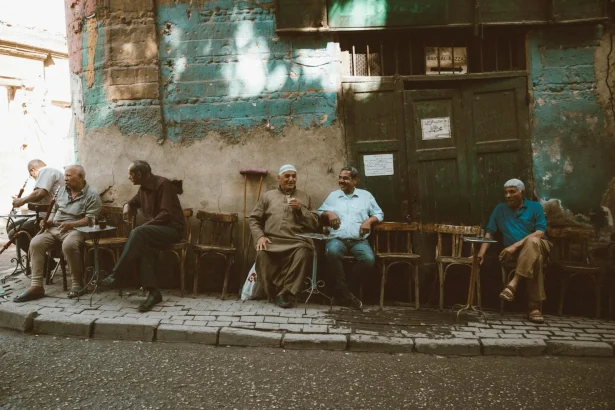 Local men enjoy a casual gathering outside a café in Cairo's historic Al-Darb Al-Ahmar district.