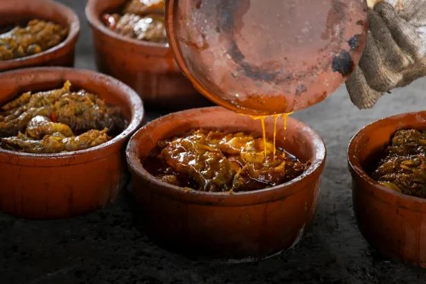 Authentic Vietnamese clay pot fish dish cooking in Nam Định, capturing the richness of Asian cuisine.