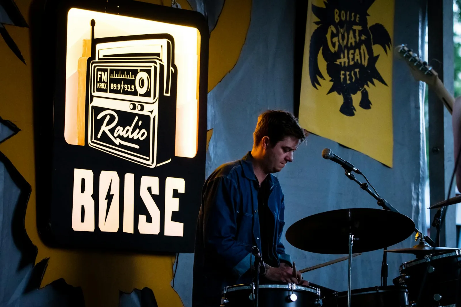 Drummer performing live on stage at Boise Goat Head Fest with vibrant festival ambiance.
