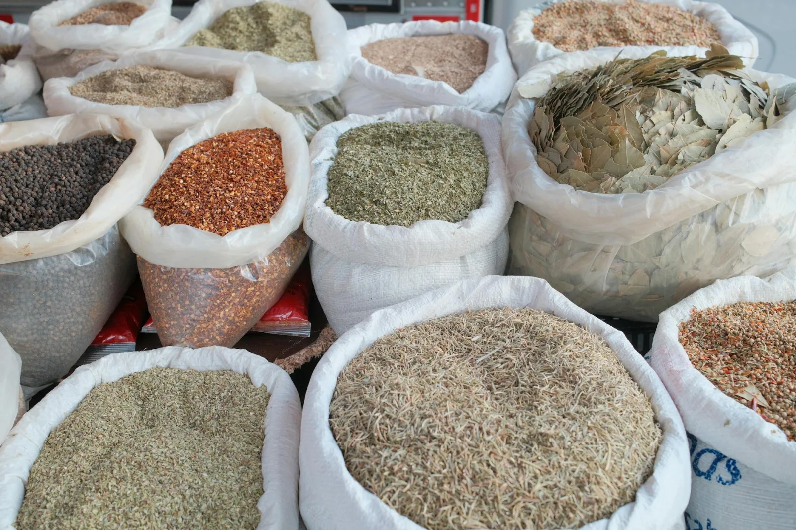 Various spices in sacks displayed at an outdoor market, showcasing diversity.