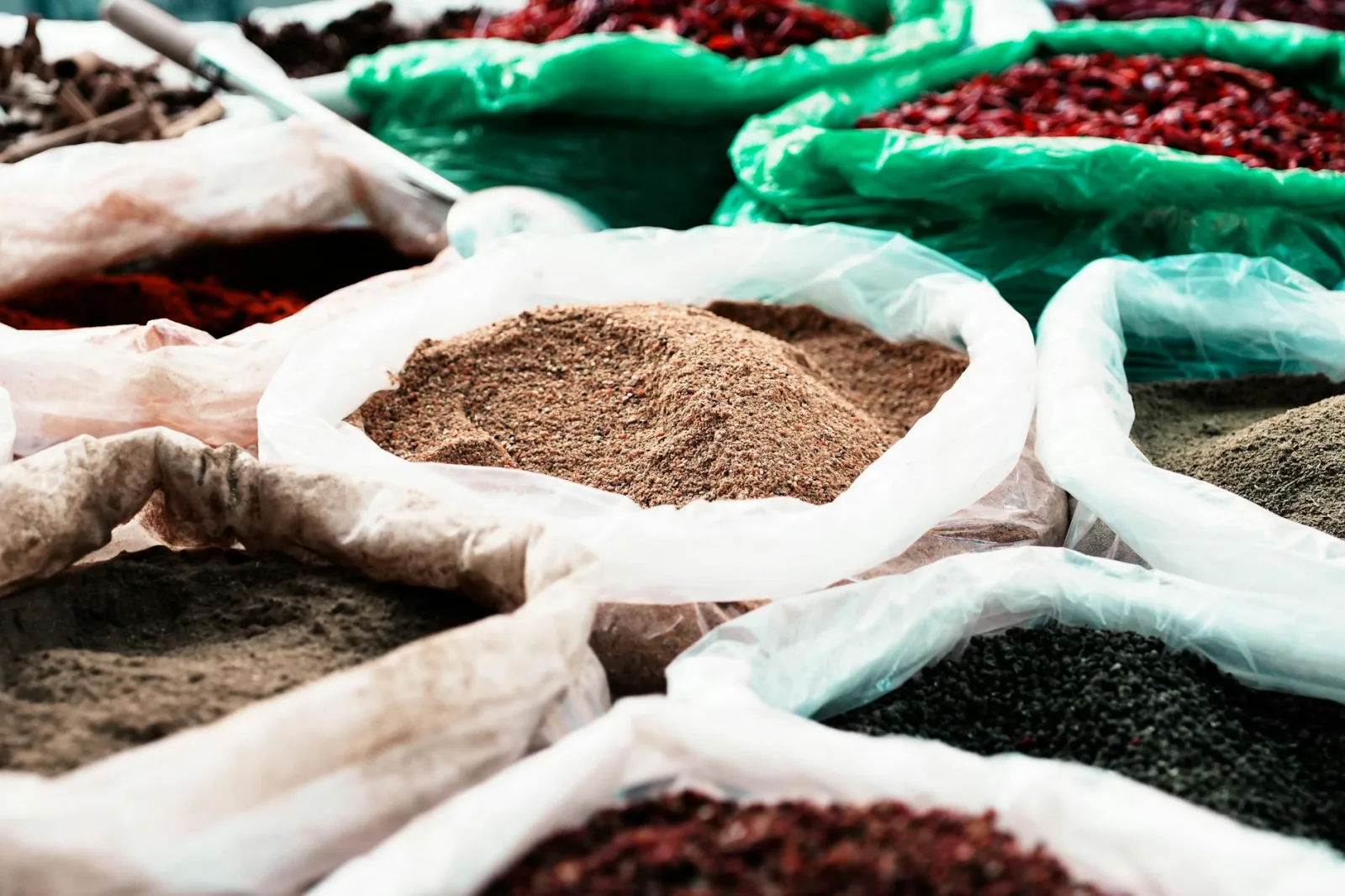 Colorful assortment of spices in bags at a traditional market, showcasing diversity.