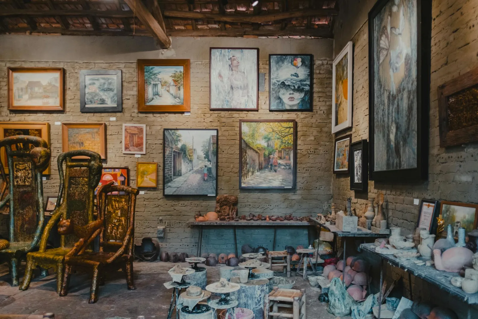 A rustic art gallery displaying a variety of eclectic artworks and sculptures in a cozy setting.