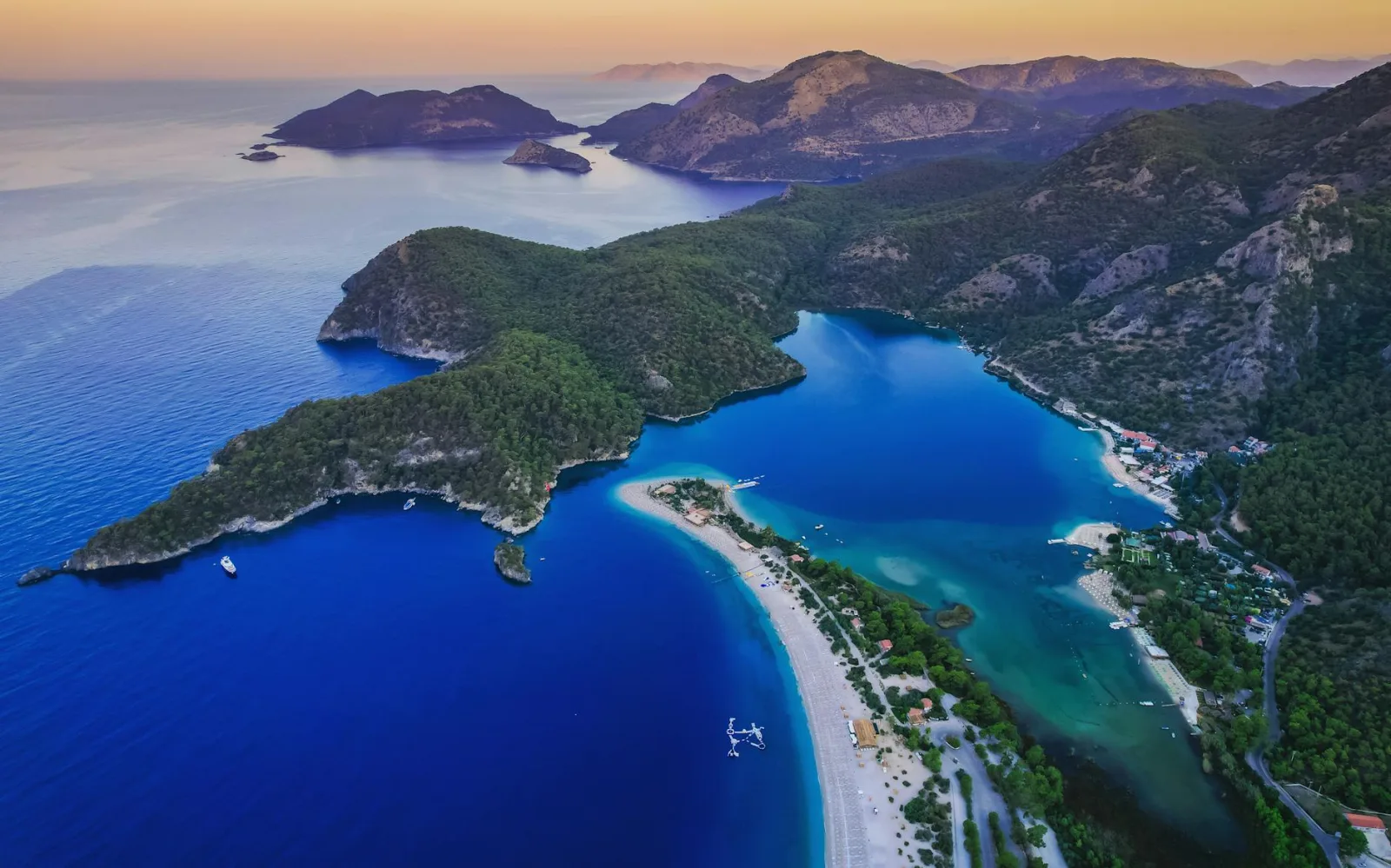 Aerial shot of a peaceful island with blue water and lush greenery.