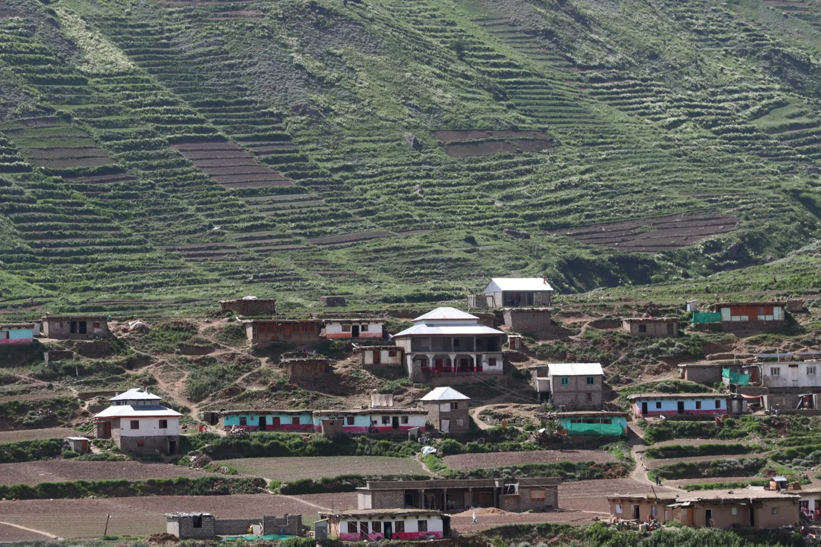 Beautiful view of a mountain village with terraced agricultural fields and traditional houses.