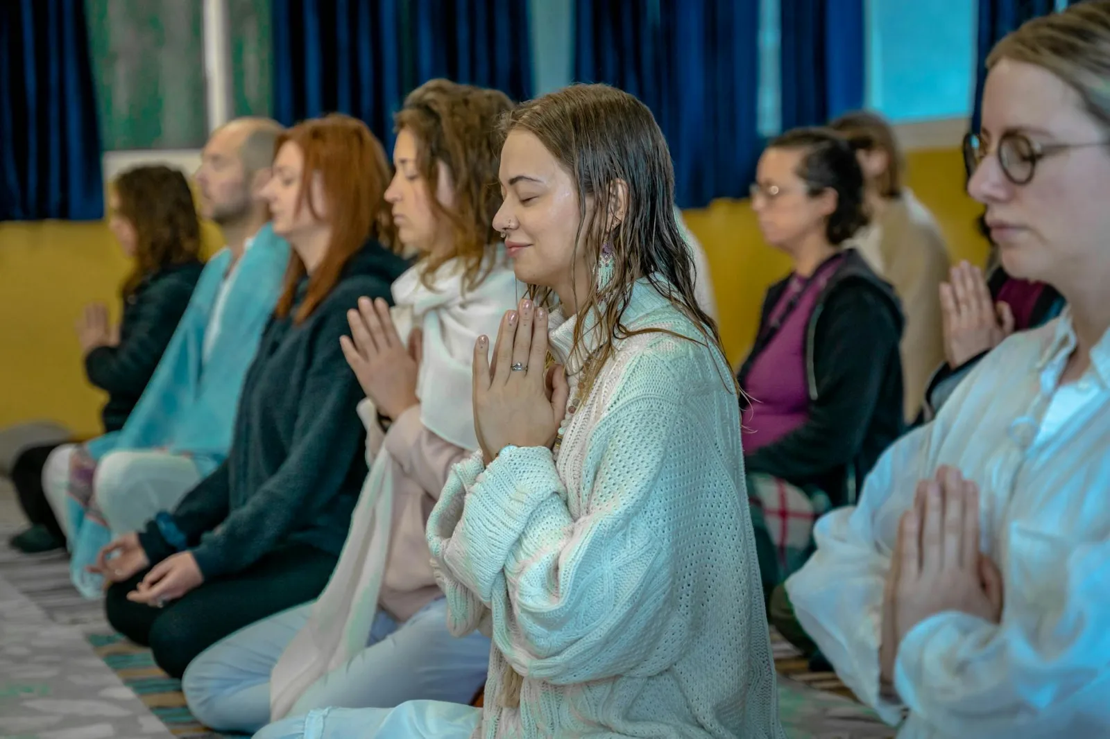 People in a meditative pose at a spiritual retreat in Rishikesh, India.
