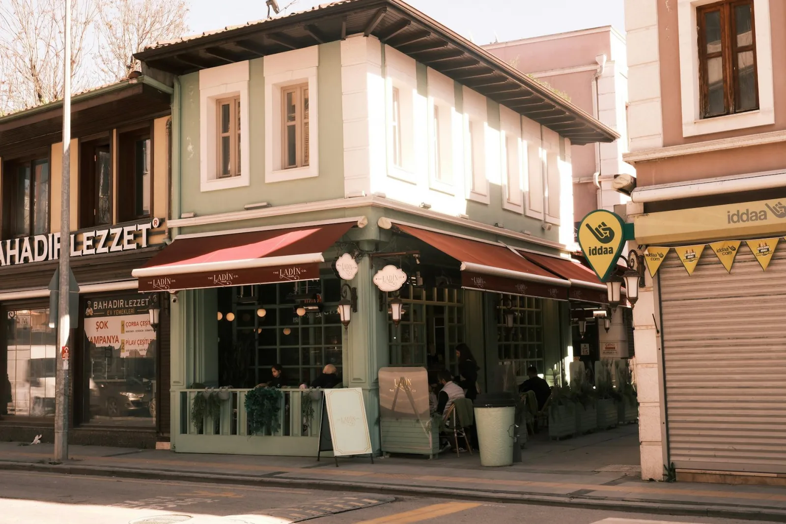 Cozy street-side cafe on a sunny day in Sakarya, Türkiye, with traditional architecture.