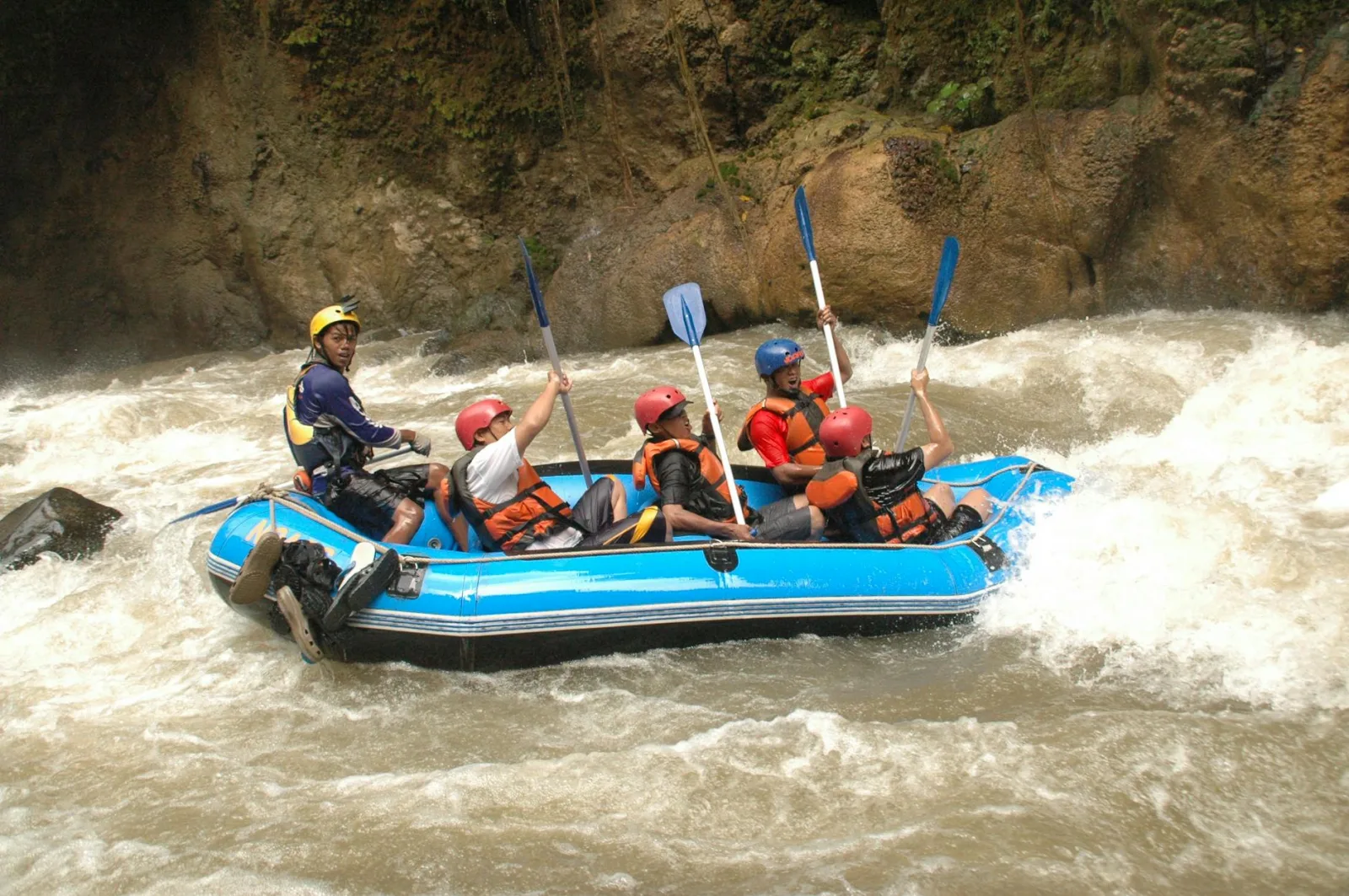 Group enjoying an exhilarating whitewater rafting adventure through challenging rapids in a raft.