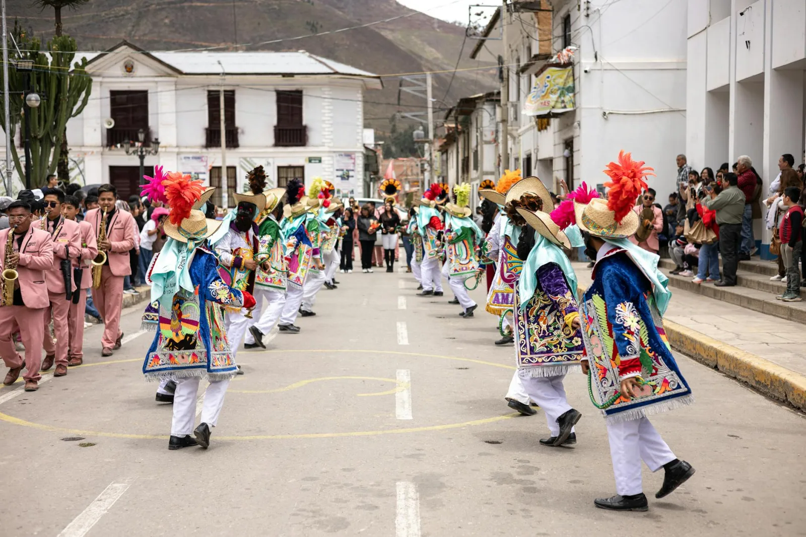 Colorful street parade with dancers in traditional costumes and musicians.