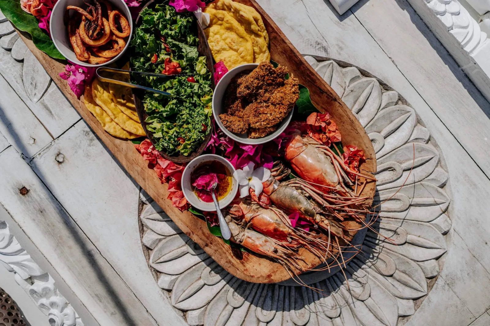 A vibrant Zanzibar seafood platter with prawns and sides on a decorative table.