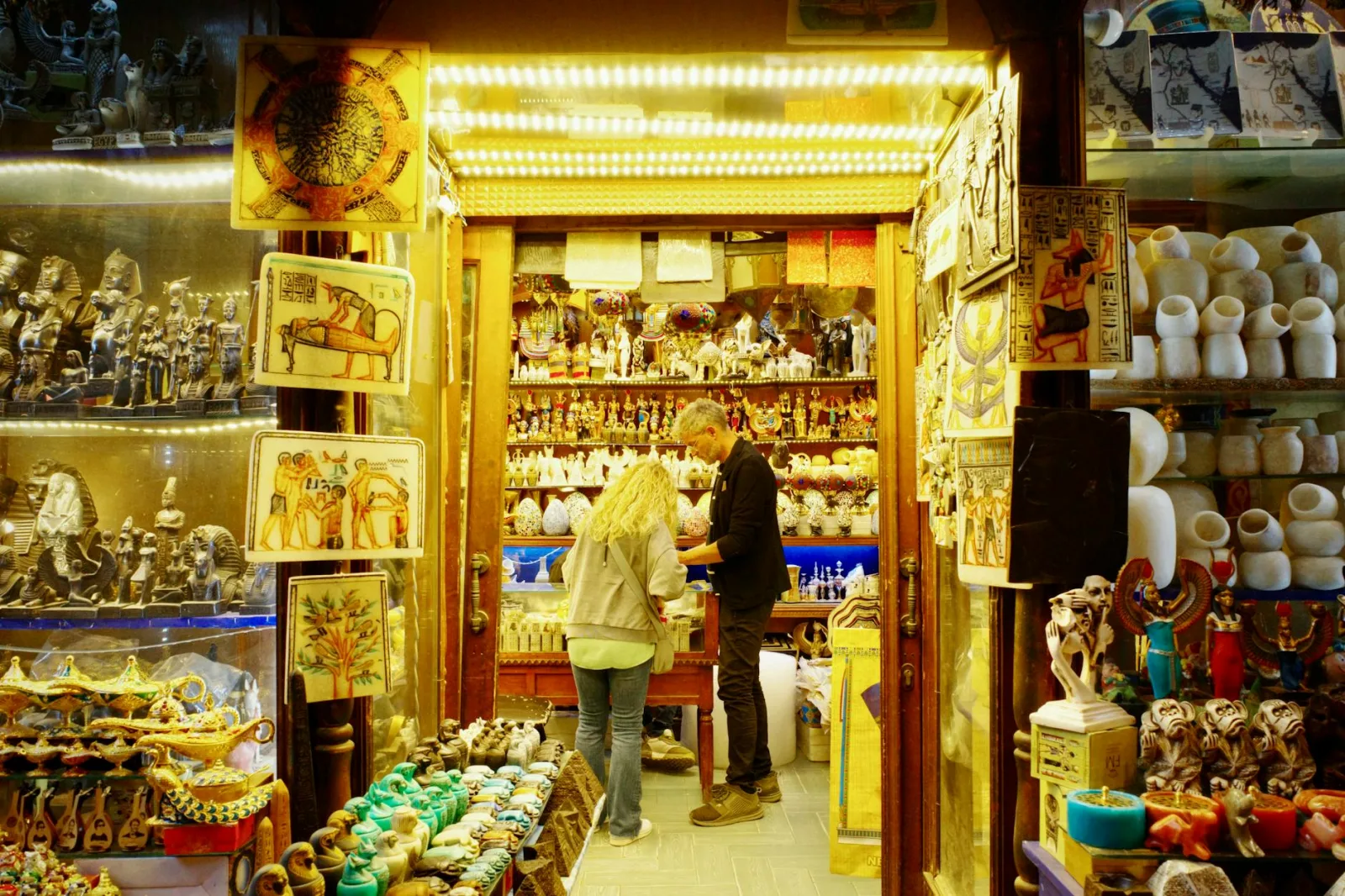 Tourists browse a vibrant souvenir shop in Cairo filled with Egyptian artifacts.