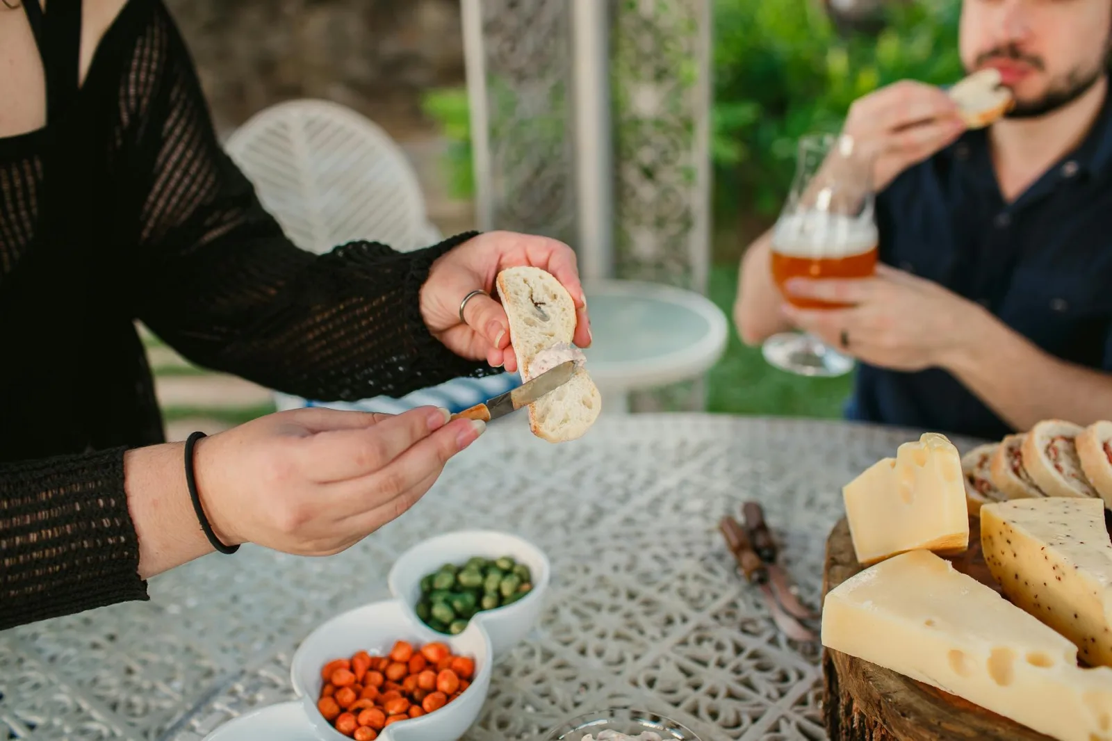 Casual outdoor gathering enjoying cheese, bread, and drinks. Perfect for any lifestyle or food-related theme.