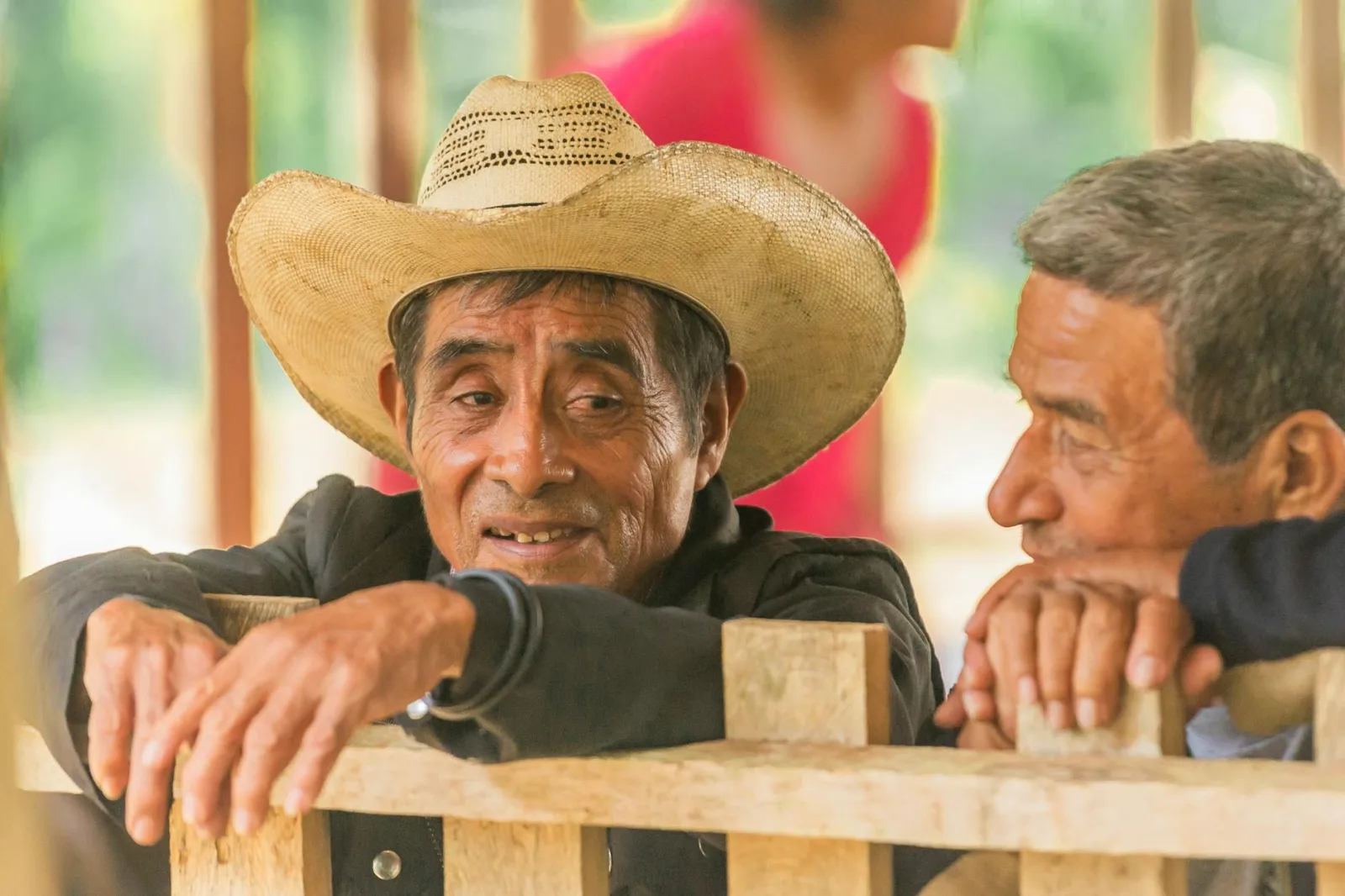 Elderly men in conversation outdoors, showcasing friendship and cultural heritage in Guatemala.