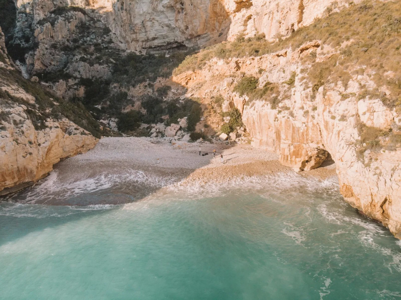 A breathtaking aerial shot of a secluded beach and rocky cliffs in Alicante, Spain.
