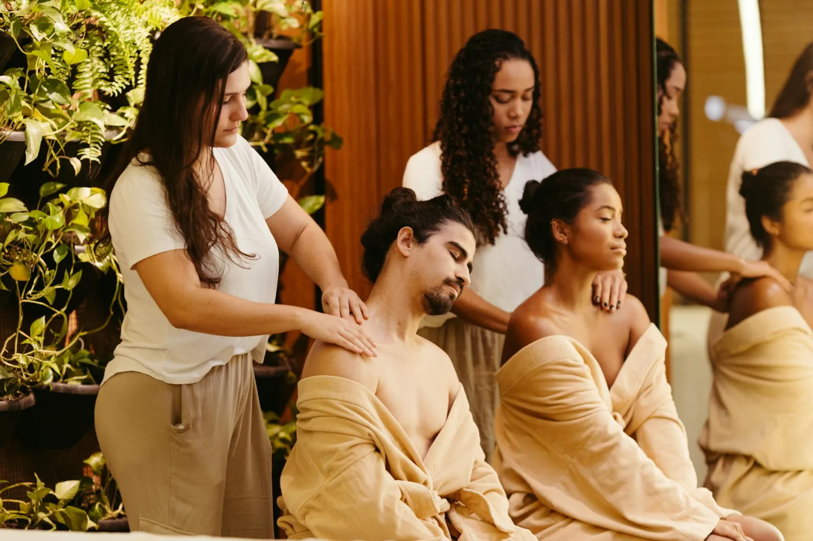 Two clients enjoy a relaxing massage from professional therapists in a spa setting, promoting wellness and relaxation.
