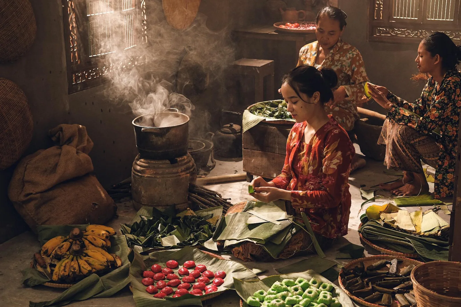 Women prepare traditional Asian food using banana leaves in a rustic kitchen setting.