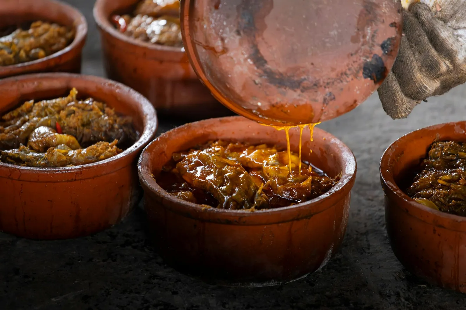 Authentic Vietnamese clay pot fish dish cooking in Nam Định, capturing the richness of Asian cuisine.