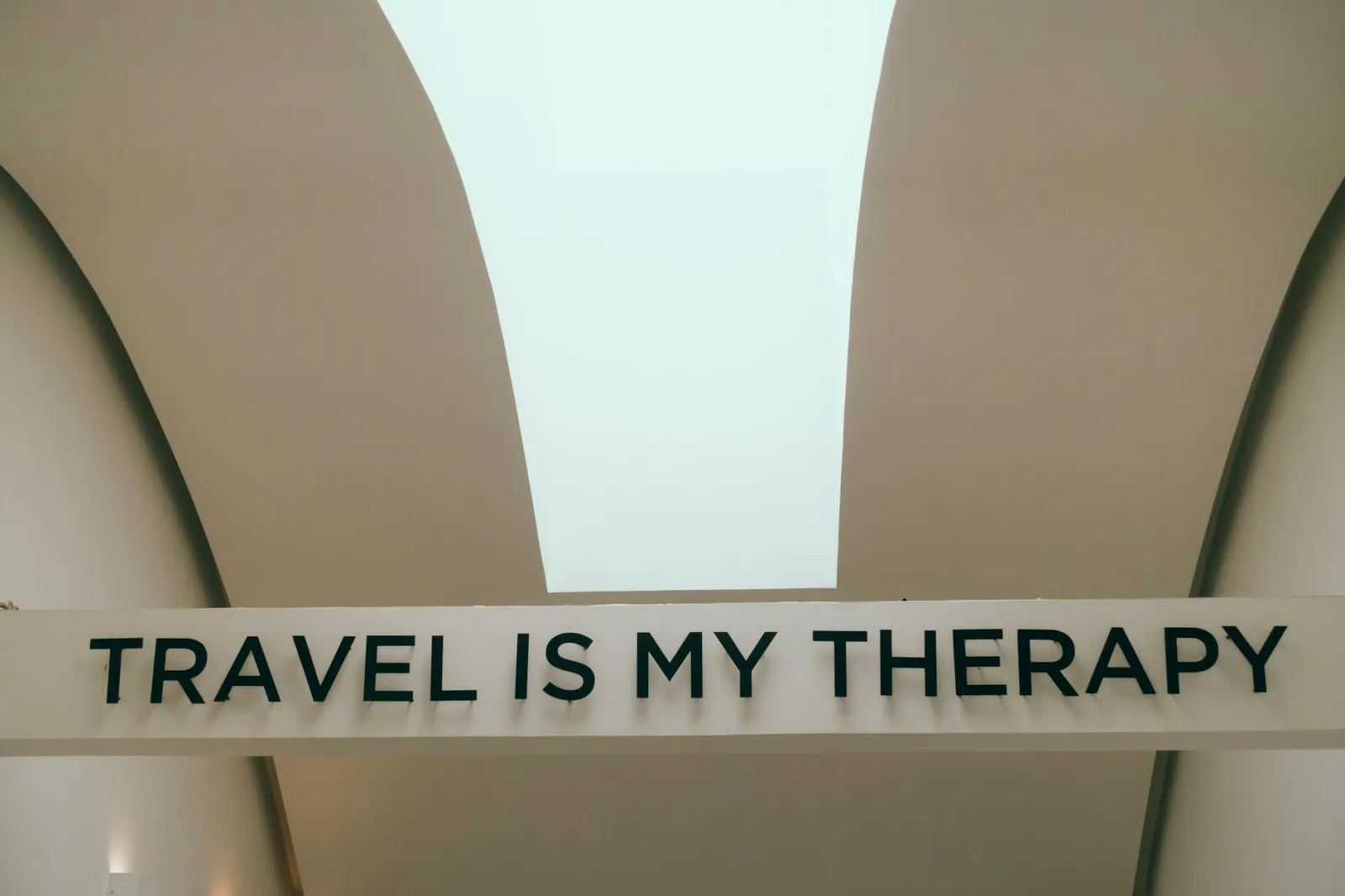 A motivational travel quote displayed in a minimalist interior setting.