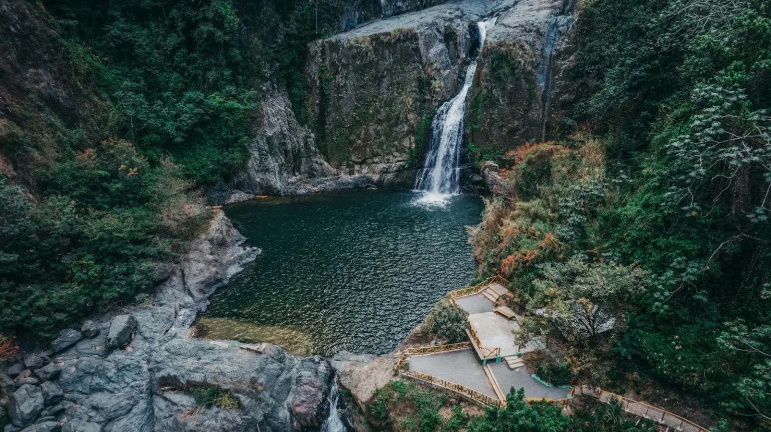 A breathtaking aerial view of a waterfall and forest pool in Jarabacoa, Dominican Republic.