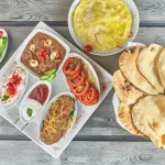 A vibrant spread of Middle Eastern dishes featuring hummus, falafel, and fresh vegetables.