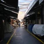 A quiet market alleyway with colorful canopies overhead, capturing an urban setting