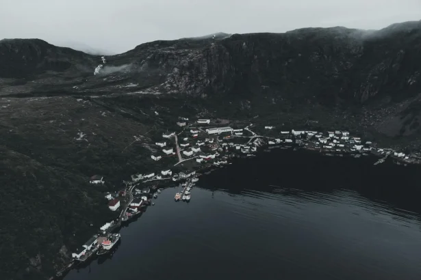 A serene aerial view of a foggy Norwegian coastal village surrounded by fjords.