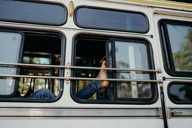 A person rests their bare foot outside a window on a bus ride through India.