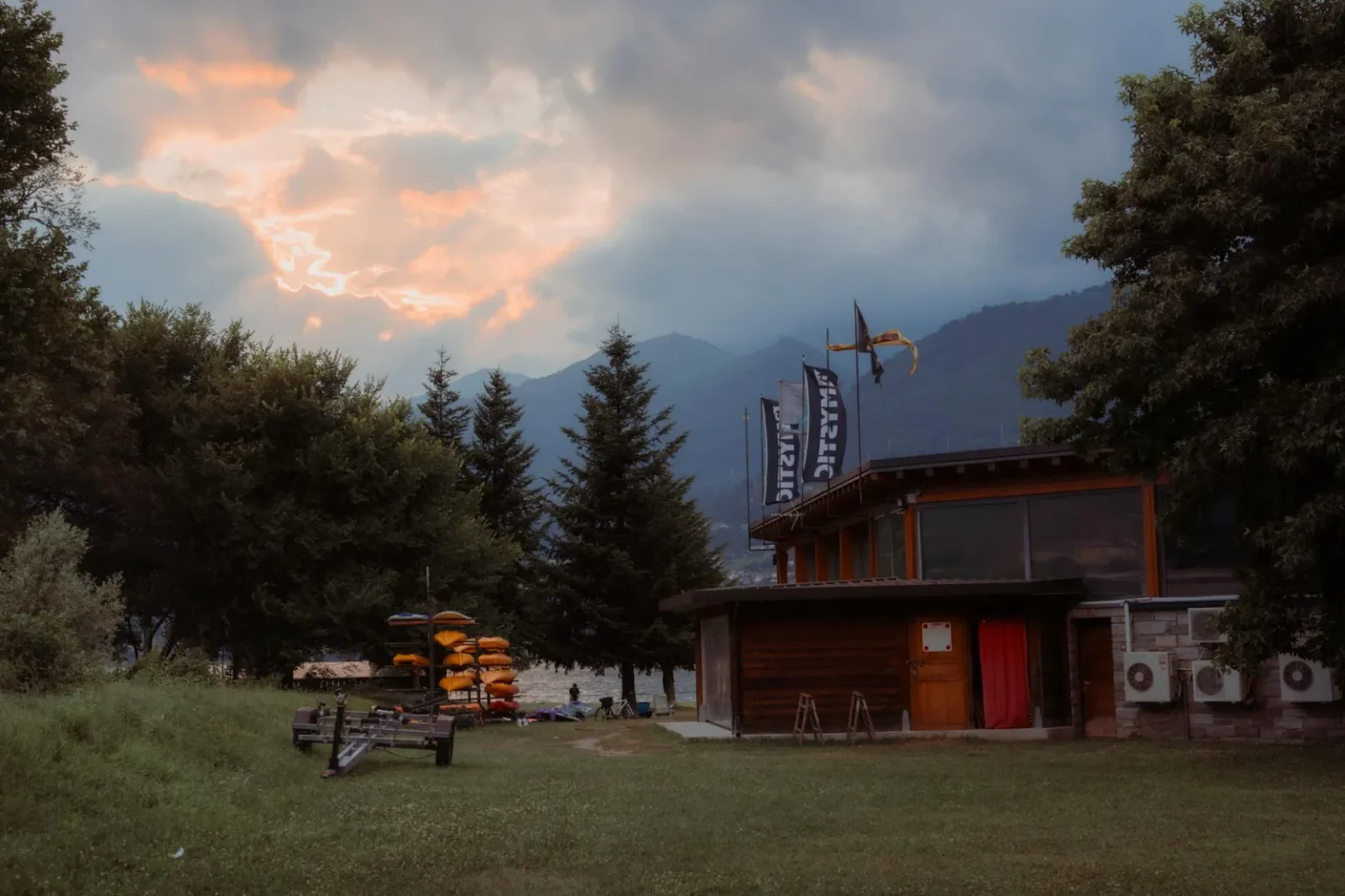 Serene evening scene at Lake Como with scenic mountain views and a kayak rental hut.