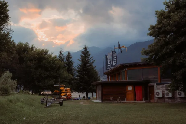 Serene evening scene at Lake Como with scenic mountain views and a kayak rental hut.
