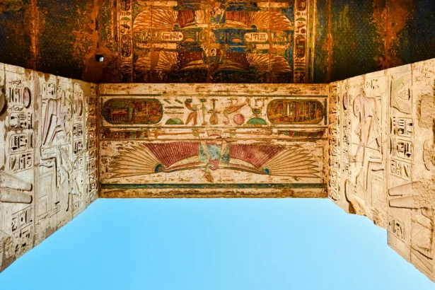 Vivid depiction of Egyptian hieroglyphs on a temple ceiling in Luxor, showcasing historic art.
