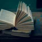 An open vintage book on a rustic wooden table, evoking a sense of nostalgia and wisdom.