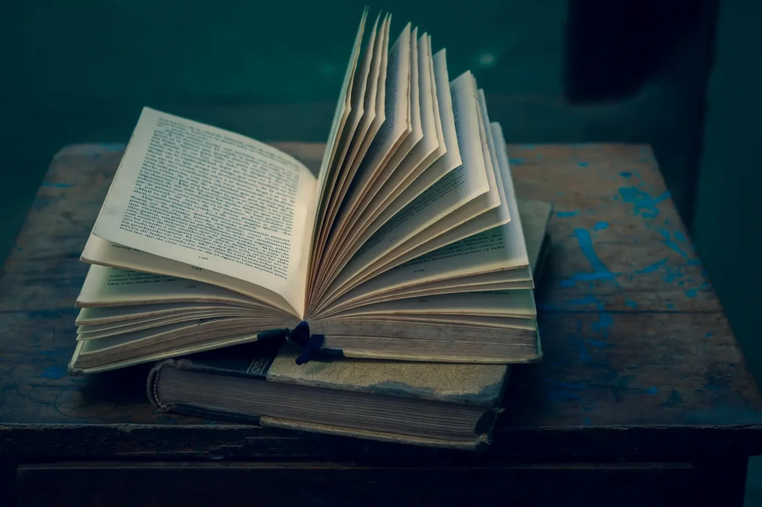 An open vintage book on a rustic wooden table, evoking a sense of nostalgia and wisdom.