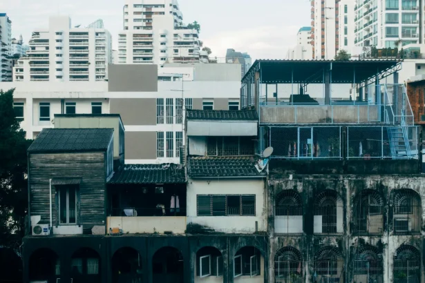 A juxtaposition of aging and modern urban buildings in a dense city landscape.