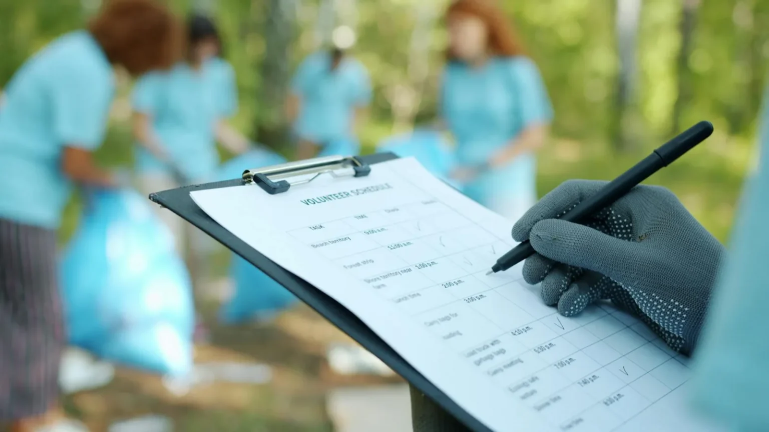 Volunteers working together on an outdoor cleanup project, checking schedule.