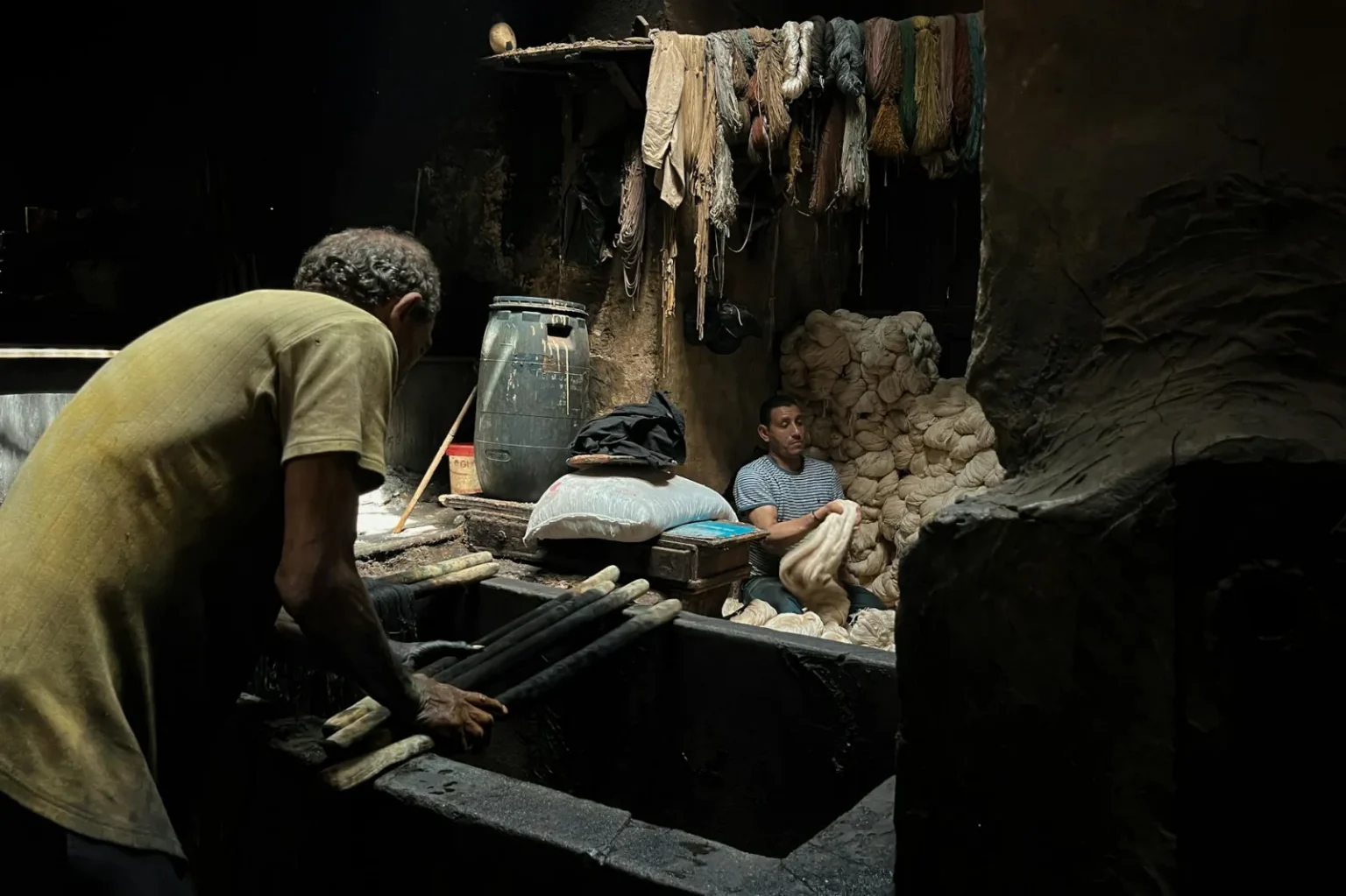 Authentic scene of two men working in a textile dyeing workshop in Cairo, Egypt.