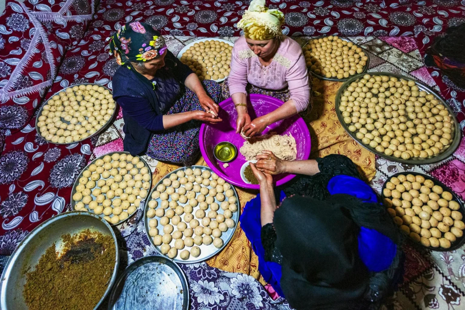 Women collaboratively preparing traditional bread, showcasing culture and teamwork.