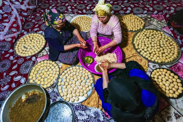 Women collaboratively preparing traditional bread, showcasing culture and teamwork.