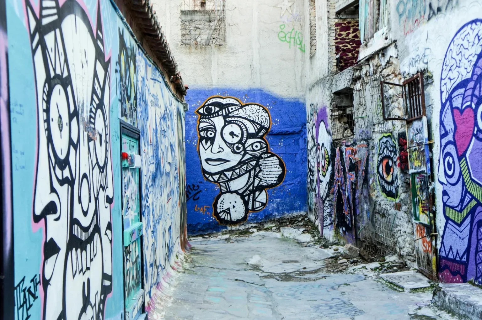 Colorful graffiti art adorns the walls in a narrow alley in Athens, showcasing urban creativity.
