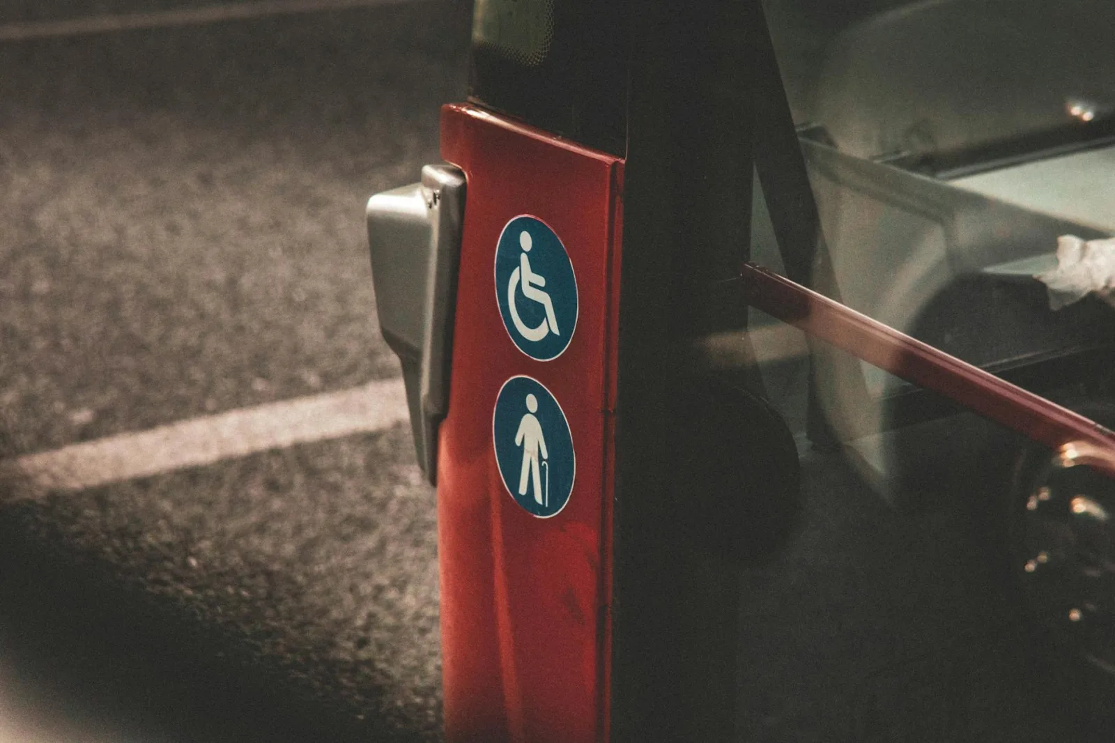 Close-up view of accessibility and elderly symbols on a red city bus.