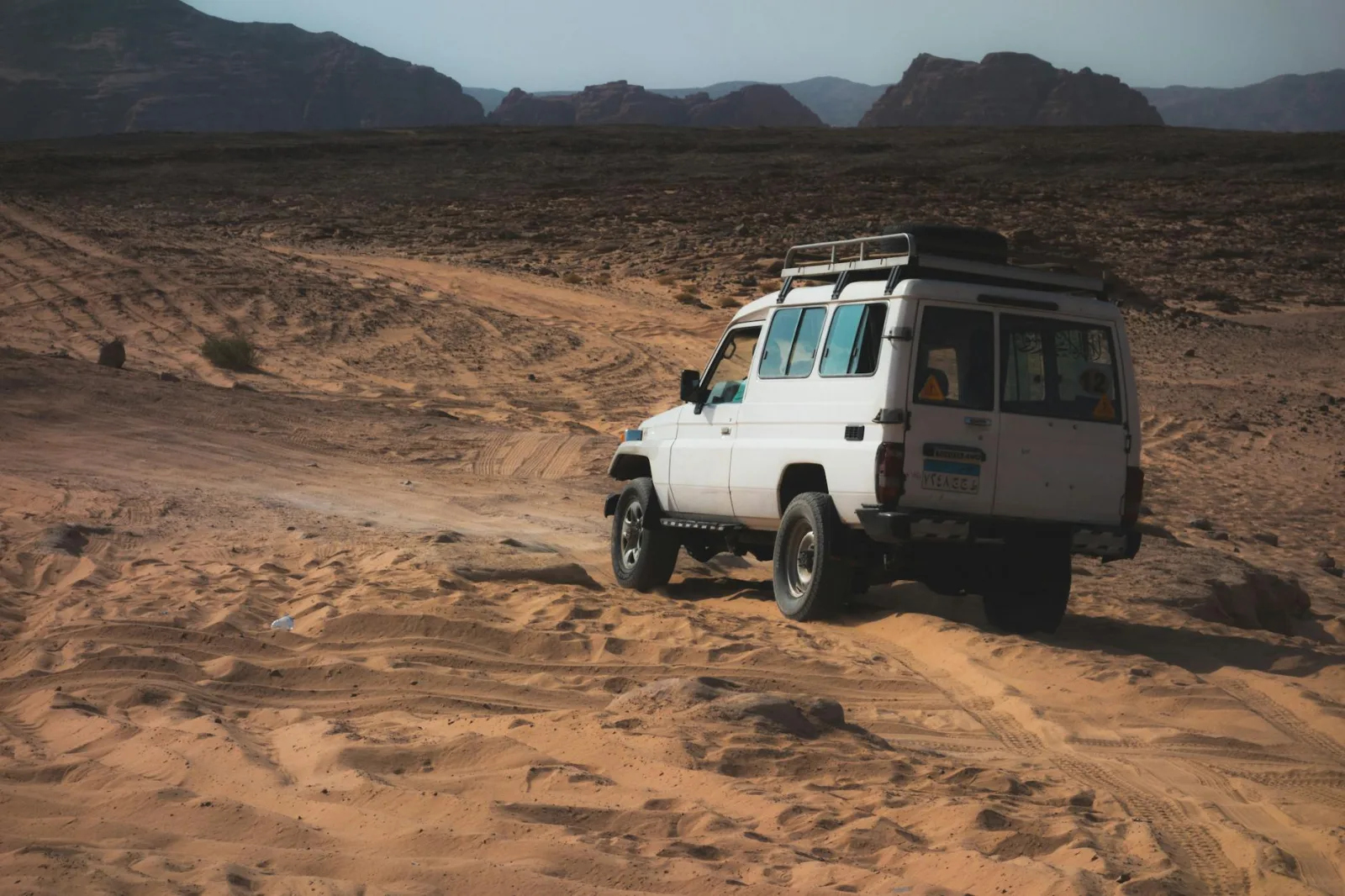 A 4x4 vehicle explores the Egyptian desert, showcasing offroad adventure.