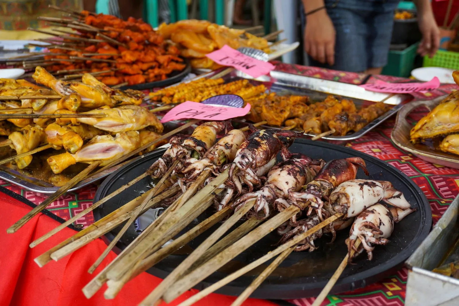 Colorful display of skewered seafood and meats at a traditional Filipino street food market in Iloilo City.